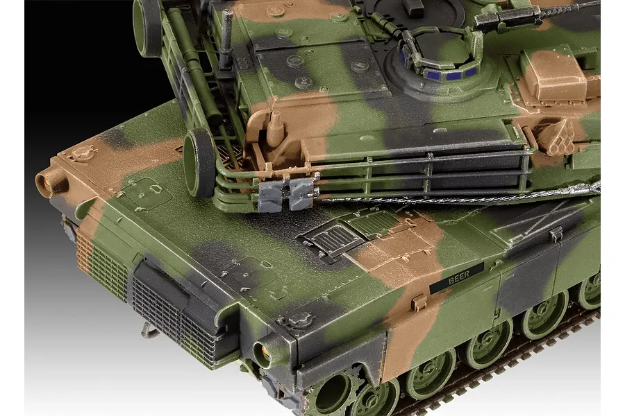 Close-up of a 1/72 scale M1 Abrams tank model kit with camouflage paint, showing the turret and hull details.