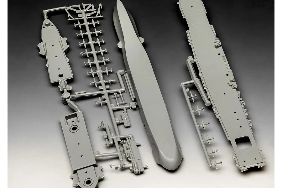 Grey plastic model kit sprues for a 1/1200 scale USS Enterprise aircraft carrier, including the hull, flight deck, and small aircraft components.