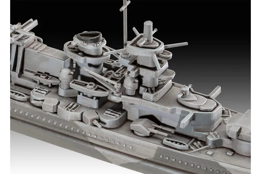 Close-up of the superstructure and deck of a grey plastic model battleship, showing detailed gun turrets, funnels, and masts.