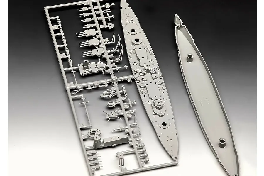 Grey plastic model kit sprue containing parts for a 1/1200 scale Gneisenau battleship model, including the deck and hull sections.