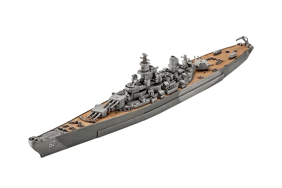 A high-angle studio shot of a 1/1200 scale Revell USS New Jersey battleship plastic model kit, showing the grey hull and tan deck.