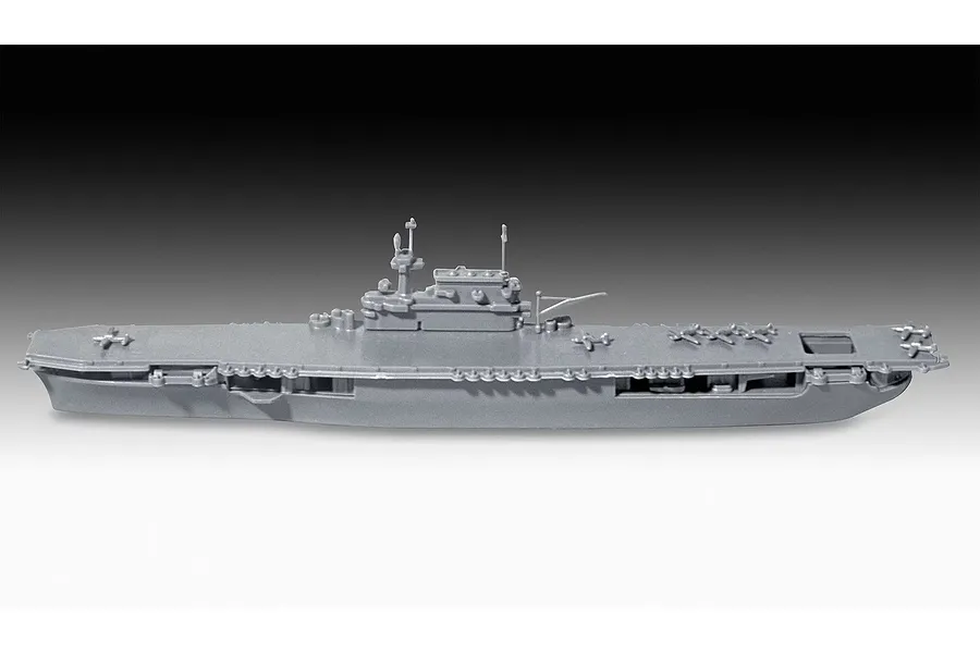A side-profile view of an unpainted grey plastic model of the USS Enterprise CV-6 aircraft carrier, showing the flight deck and island structure.