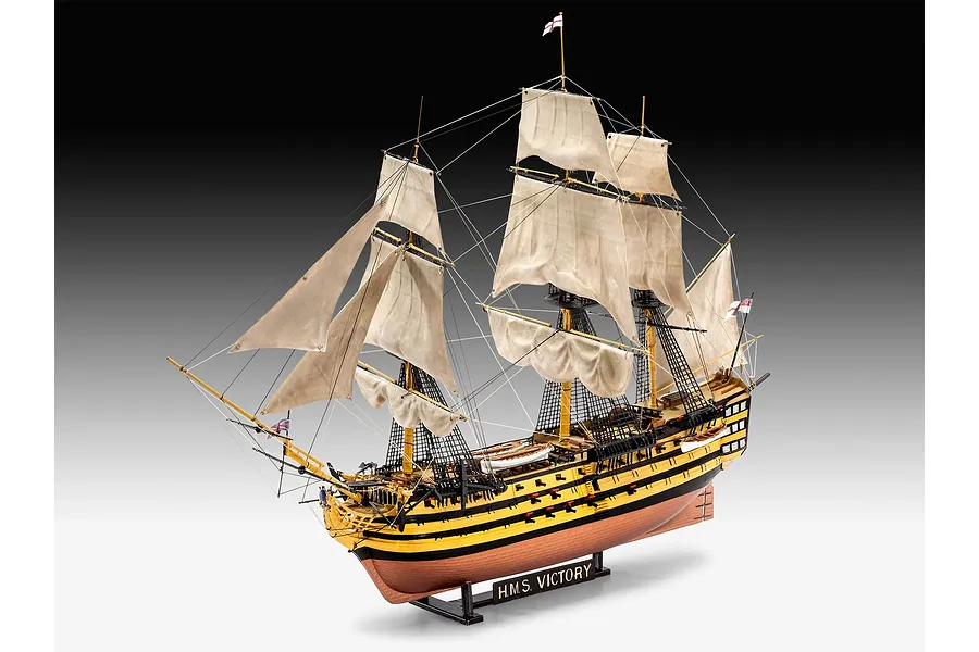 A fully assembled and painted 1/225 scale plastic model of the HMS Victory ship, featuring detailed sails, rigging, and a display stand.