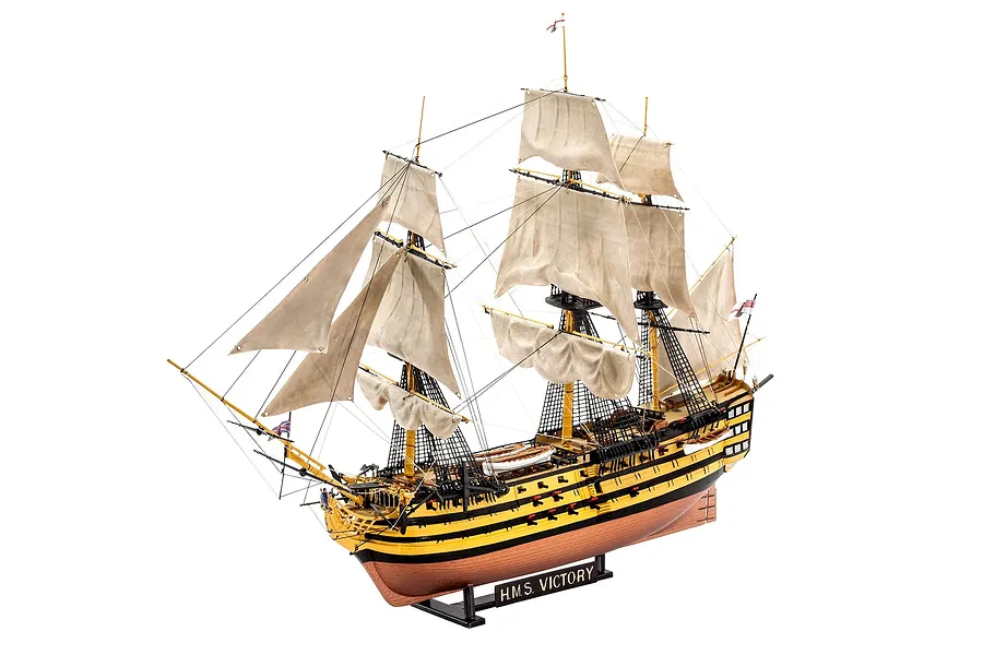 A fully assembled and painted 1/225 scale plastic model of the HMS Victory ship, featuring detailed sails, rigging, and a black display stand.