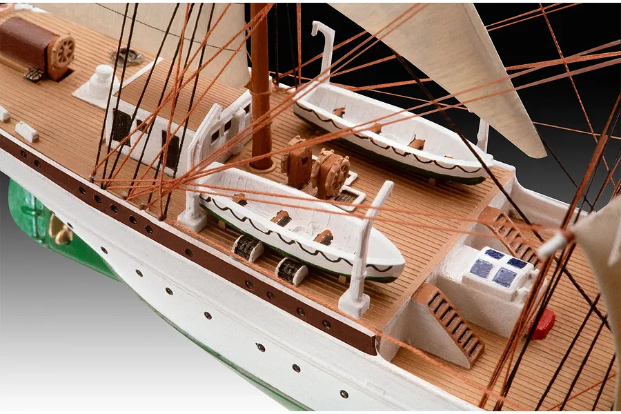 Close-up of the deck of a Gorch Fock ship model, showing lifeboats, rigging, and wooden-textured decking.