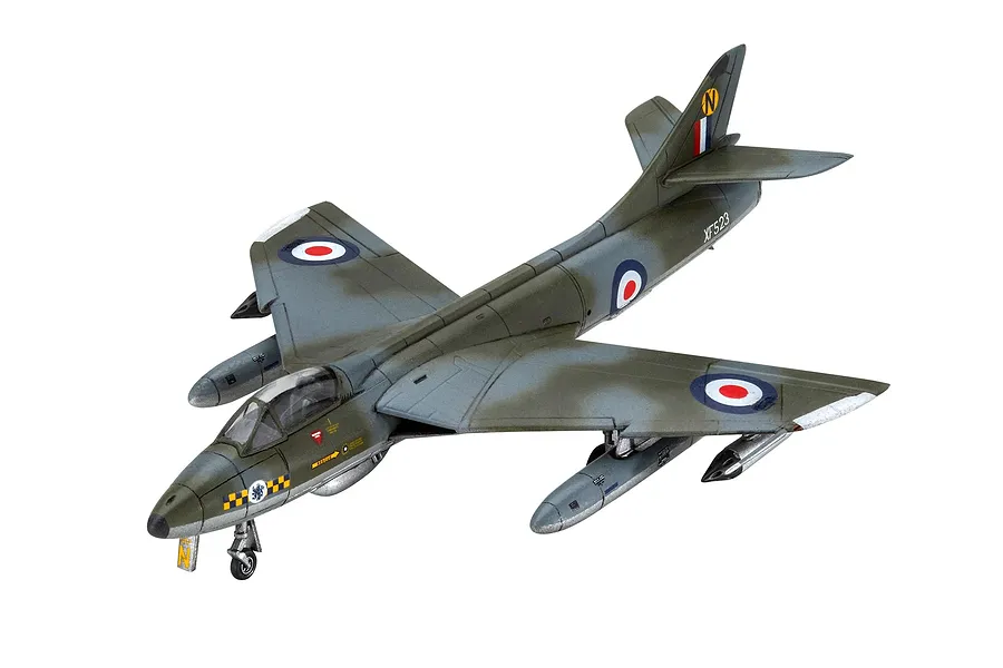 A completed 1/144 scale plastic model of a Hawker Hunter FGA.9 jet aircraft, painted in camouflage with RAF markings and external fuel tanks.