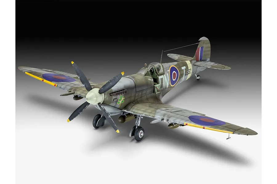 A completed 1/32 scale plastic model of a Supermarine Spitfire Mk.IXc fighter plane, painted in camouflage with RAF markings and a maple leaf emblem.