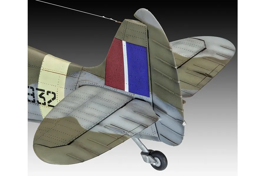Close-up of the tail section of a painted 1/32 scale Supermarine Spitfire model, showing the rudder, horizontal stabilizers, and tail wheel.