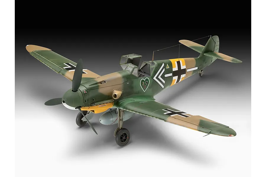 A completed 1/32 scale plastic model of a Messerschmitt Bf 109 fighter aircraft with green and tan camouflage and a heart emblem on the side.