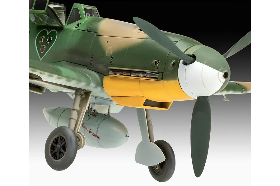 Close-up of a 1/32 scale Messerschmitt Bf 109 model aircraft showing the nose, propeller, and landing gear with a drop tank labeled 'Keine Bombe!'.
