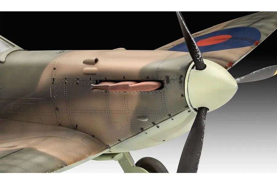 Close-up of a 1/32 scale plastic model Spitfire aircraft showing the nose, propeller, and camouflage paint scheme.
