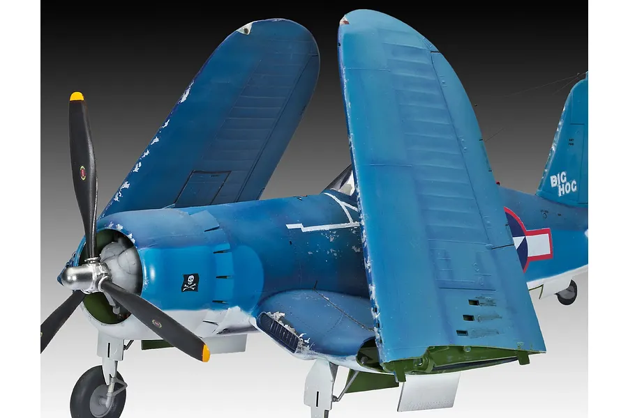 A completed 1/32 scale plastic model of a Vought F4U-1A Corsair with its wings folded upwards, featuring weathered blue paint and Big Hog markings.