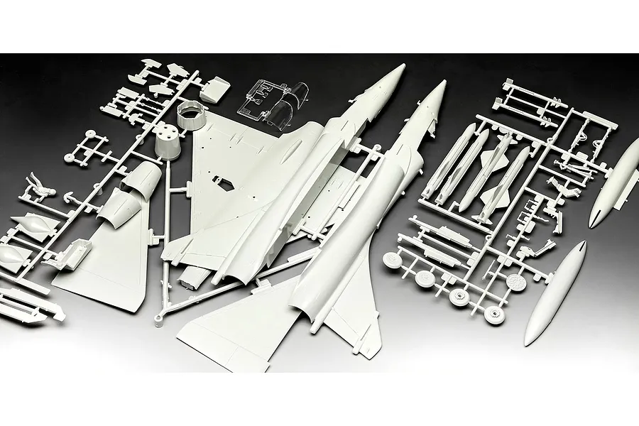 Unassembled plastic model kit parts for a Dassault Mirage 2000 C fighter jet, including fuselage halves, wings, and weapons on grey sprues.