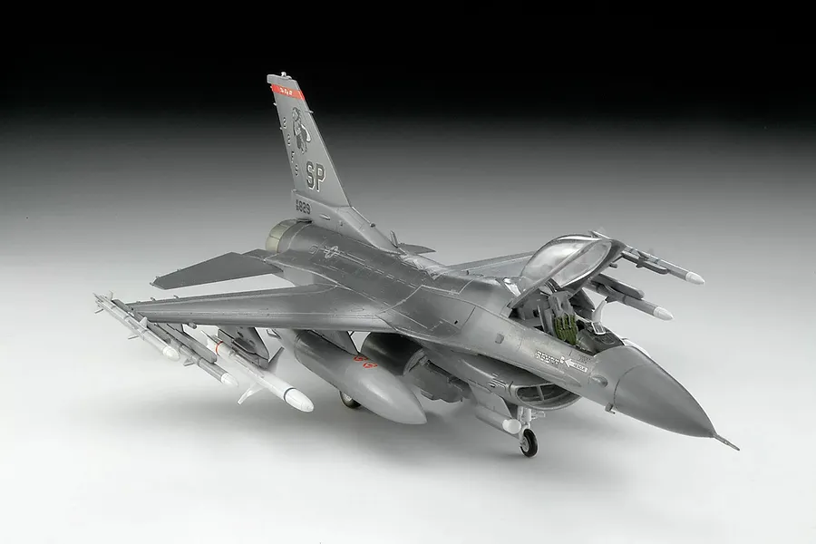 A 1/72 scale plastic model of an F-16 Fighting Falcon jet fighter, painted in grey with US Air Force markings, shown on a white background.
