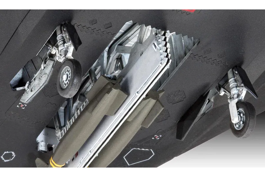 Close-up view of the underside of a plastic model F-117 Nighthawk showing landing gear and weapon bay details.