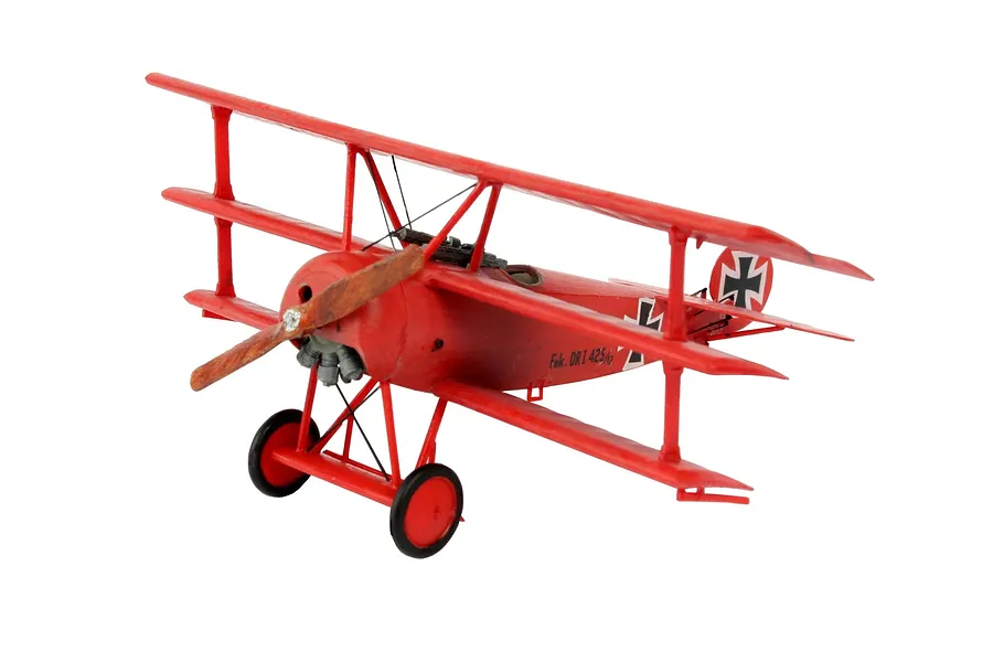 A fully assembled and painted red Fokker Dr.I triplane model aircraft on a white background.