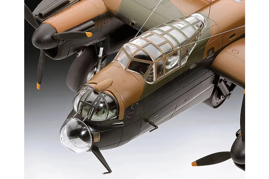 Close-up of a 1/72 scale plastic model of an Avro Lancaster bomber, showing the cockpit, nose turret, and engine nacelles with camouflage paint.