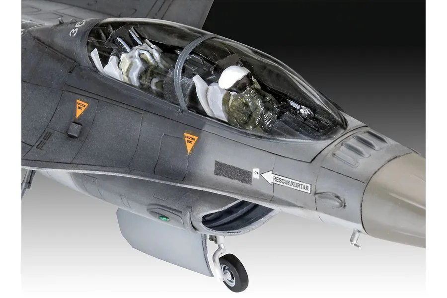 Close-up of the cockpit and nose section of a 1/72 scale plastic model F-16 fighter jet, showing the pilot figure and detailed decals.
