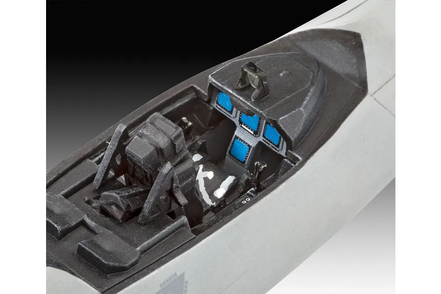 Close-up of the assembled and painted cockpit interior of a 1/72 scale F-22A Raptor model kit, showing the seat, instrument panel, and control stick.