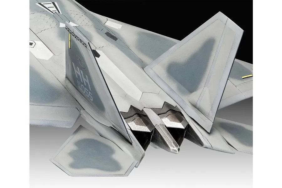 Close-up view of the rear section of a painted F-22A Raptor model aircraft, showing the tail fins, exhaust nozzles, and camouflage paint scheme.