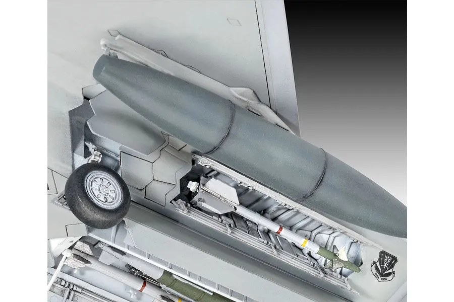 Close-up of the underside of a 1/72 scale F-22 Raptor model showing the landing gear, weapon bay, and external fuel tank.