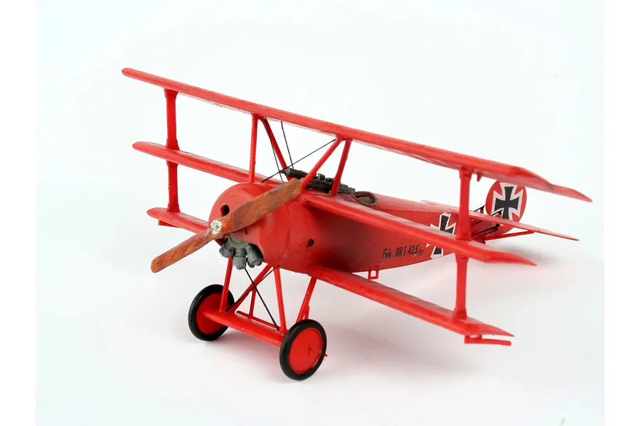 A completed 1/72 scale plastic model of a red Fokker Dr.1 Triplane on a white background.