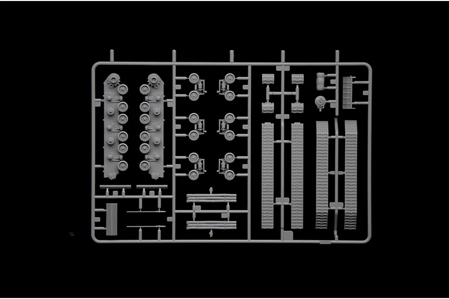A grey plastic sprue containing various tank model parts including road wheels, track sections, and suspension components.