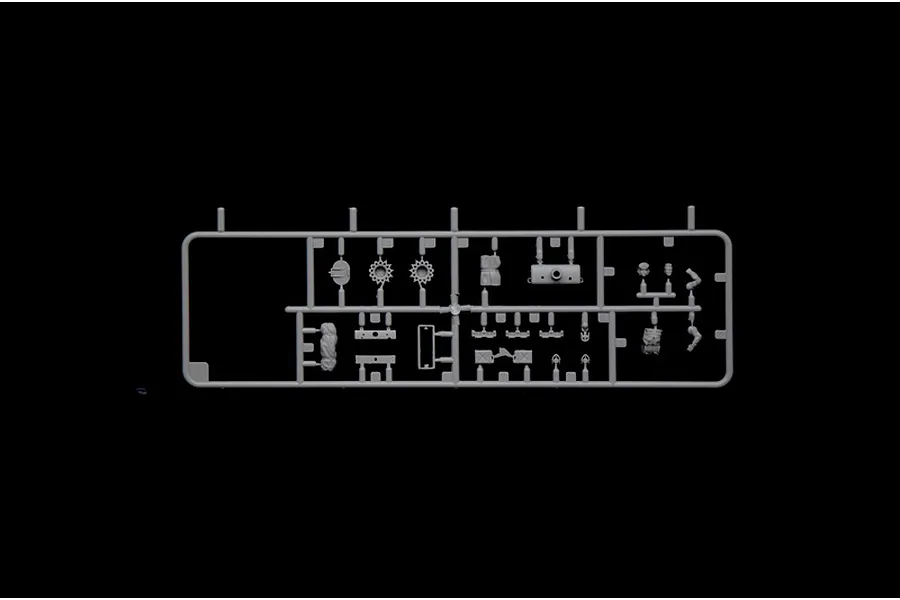 A grey plastic sprue containing various small model tank parts, including wheels and accessories, set against a solid black background.