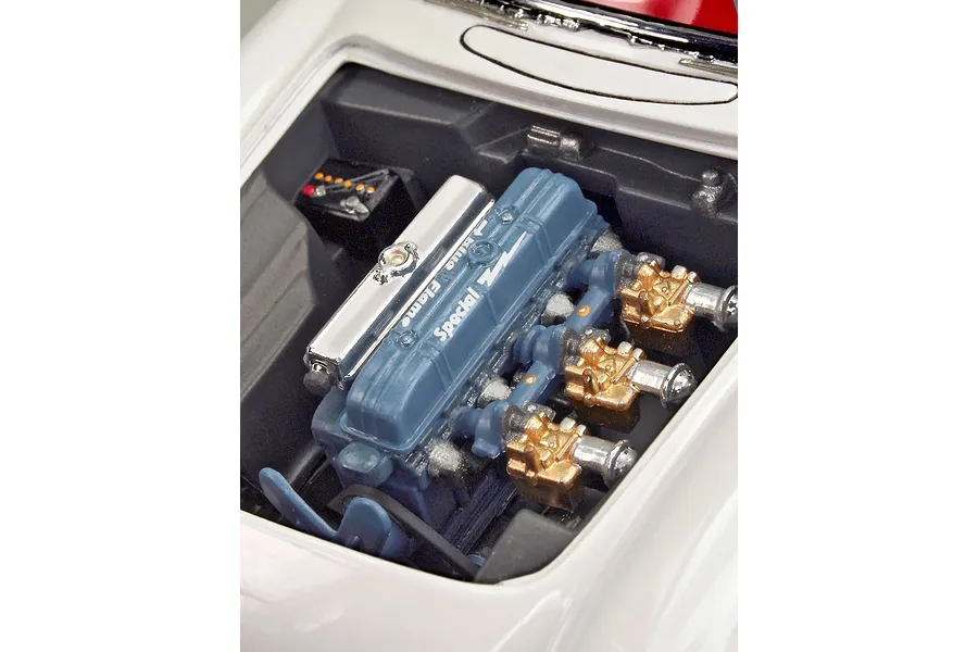A close-up view of the detailed engine bay of a 1/24 scale 1953 Chevrolet Corvette model kit, featuring a blue Blue Flame engine block.