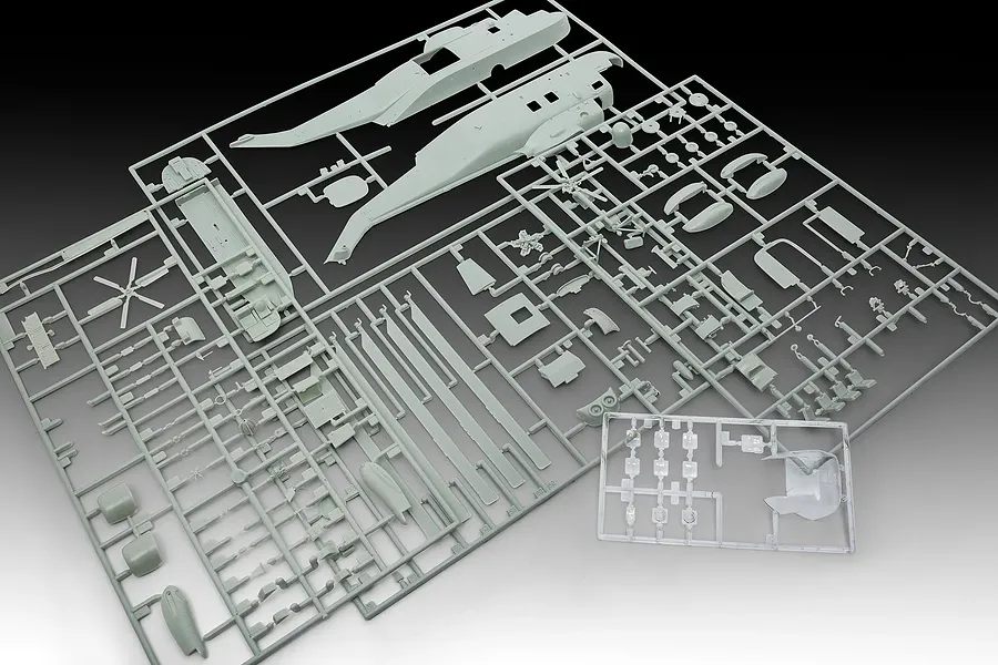 Plastic model kit sprues for a 1/72 scale Westland Sea King helicopter, showing grey fuselage halves, rotor blades, and clear cockpit parts.