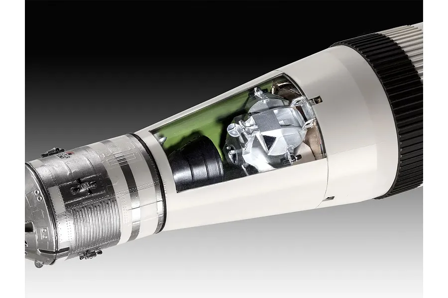 Close-up of a Saturn V model rocket showing the lunar module inside a cutaway section of the third stage.