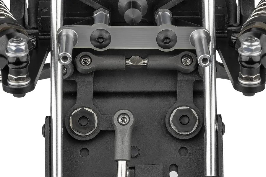 Close-up view of the front suspension and steering assembly of a Team Associated RC10 Sprint RC car kit, showing metal rods, plastic parts, and screws.