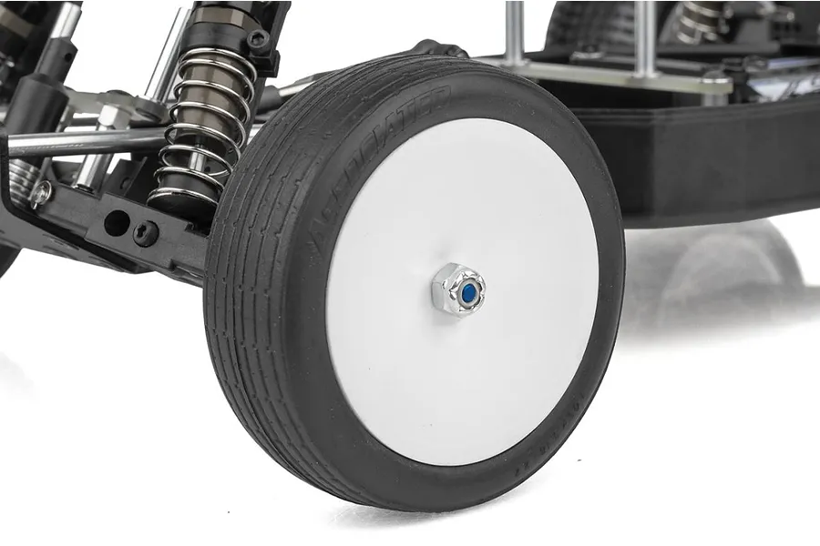 Close-up of the front wheel and suspension of a Team Associated RC10 Sprint RC car, showing a white dish wheel with a black rubber tire.