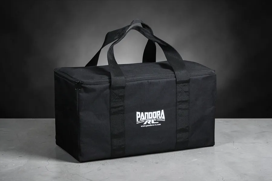 A black Pandora RC branded track bag with carrying handles, set against a dark grey studio background.