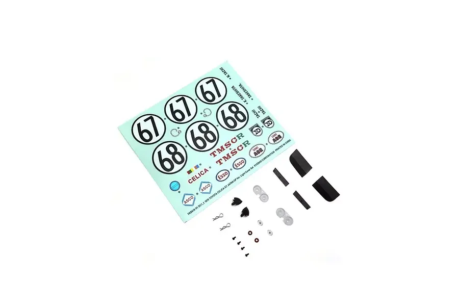 A Kyosho decal sheet and small plastic parts for a 1970 Toyota Celica RC model, including number decals, logos, headlight covers, and mounting hardware.