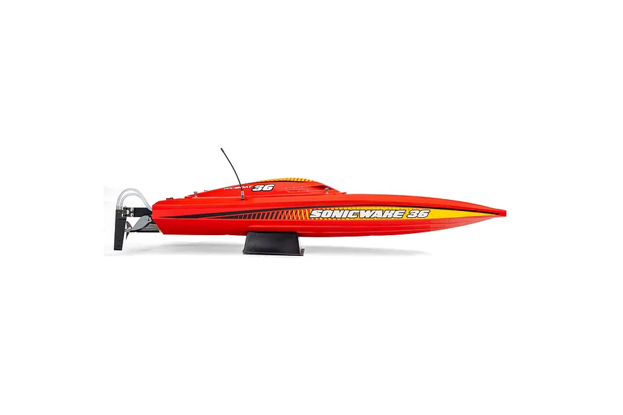 Side view of the Pro Boat Sonicwake 36 RC speed boat in red, featuring yellow accents and black branding, resting on a black display stand.