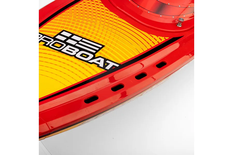 Close-up of the red deck of a Pro Boat RC speed boat showing the branding and ventilation slots.