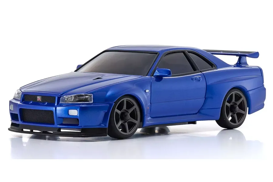 A studio shot of a metallic blue Kyosho Mini-Z Nissan Skyline GT-R R34 RC car on a white background.