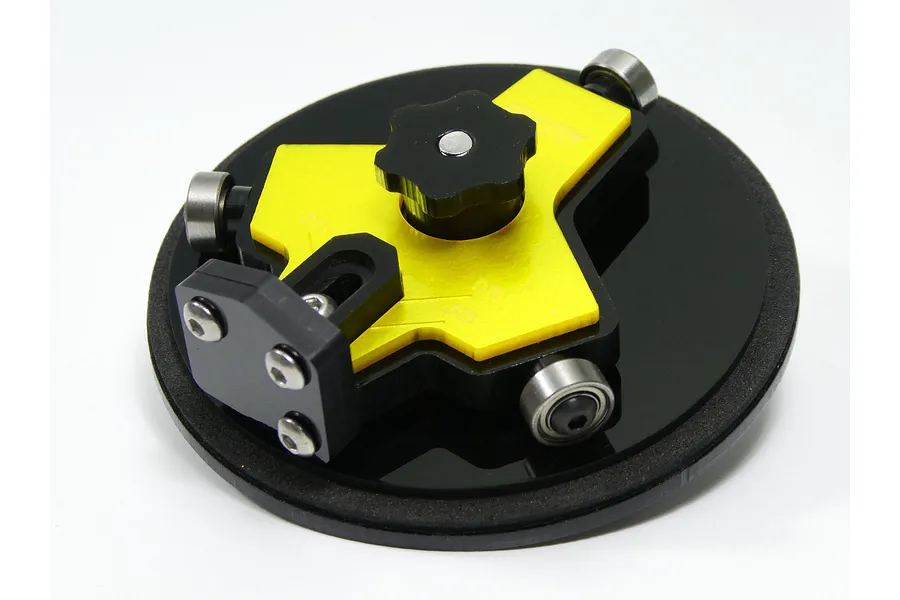 Raceform 1/8 scale RC wheel arch cutter tool with a yellow anodized plate, black plastic base, and three ball-bearing guides on a white background.