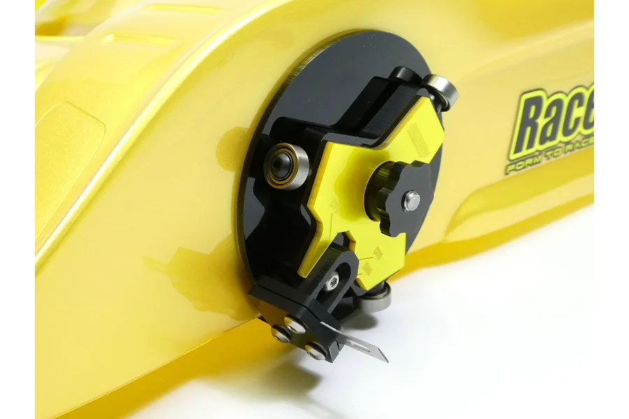 Raceform wheel arch cutter tool mounted on a yellow RC car body shell, showing the adjustable cutting blade and guide bearings.