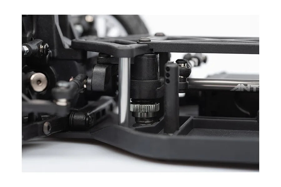 Close-up of the chassis and steering assembly of an LRP Antix S10 Blast RC buggy, showing black plastic components and metal hardware.