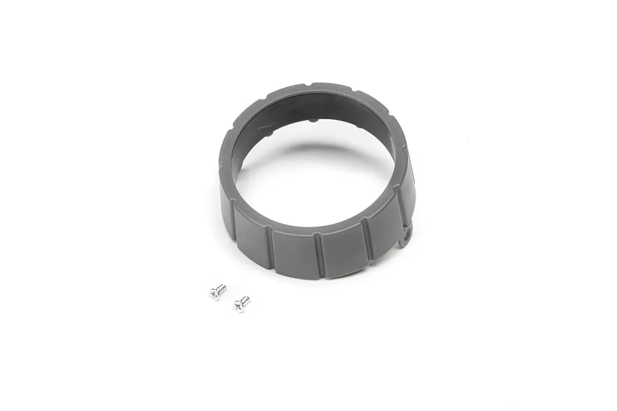 A grey plastic circular tail cone part for an RC plane with two small silver metal screws placed in front of it on a white background.