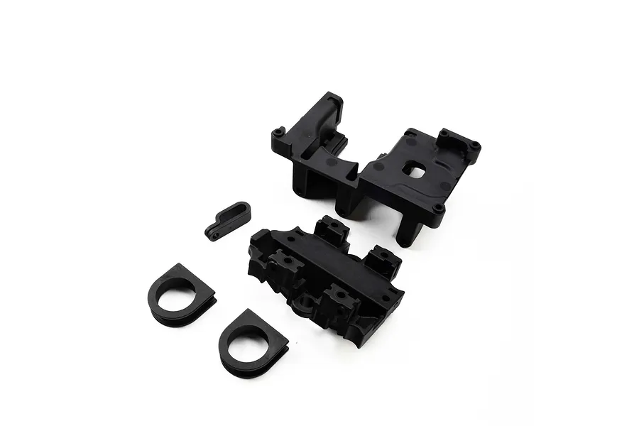 Losi RC spare parts including black plastic diff mount components and bearing inserts on a white background.