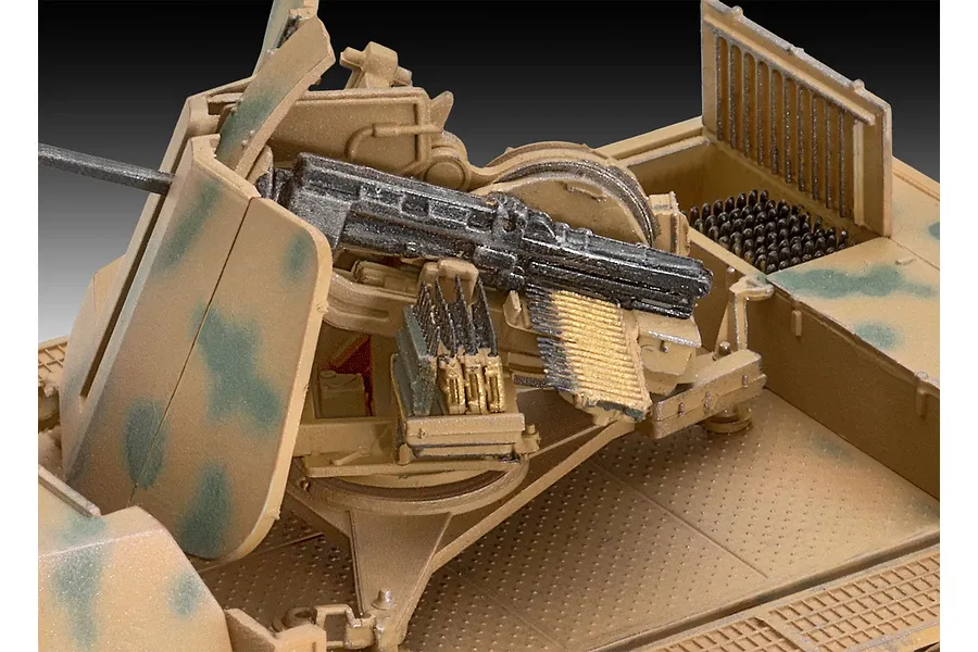 Close-up of a 1/72 scale model Flak 43 anti-aircraft gun mounted on a vehicle, featuring detailed ammunition belts and camouflage paint.