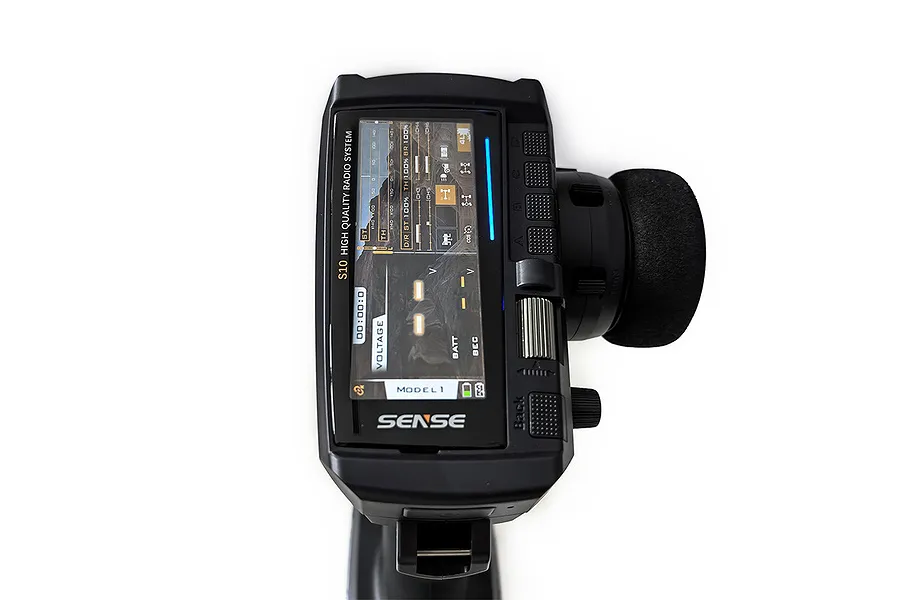 Top-down view of the Sense Innovations S10 10-channel RC transmitter showing the digital display screen and steering wheel.