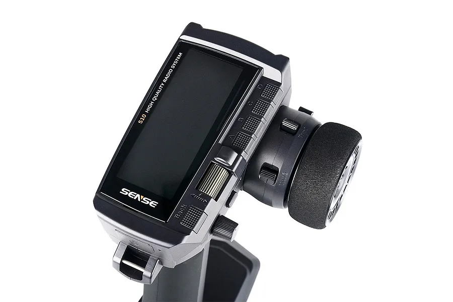 Sense Innovations S10 10-channel RC transmitter with a black steering wheel, LCD screen, and various control buttons on a white background.