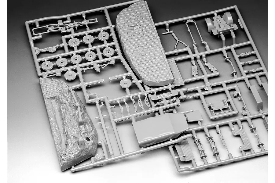 Grey plastic model kit sprue containing various vehicle parts and a textured base section for a 1/76 scale military model.