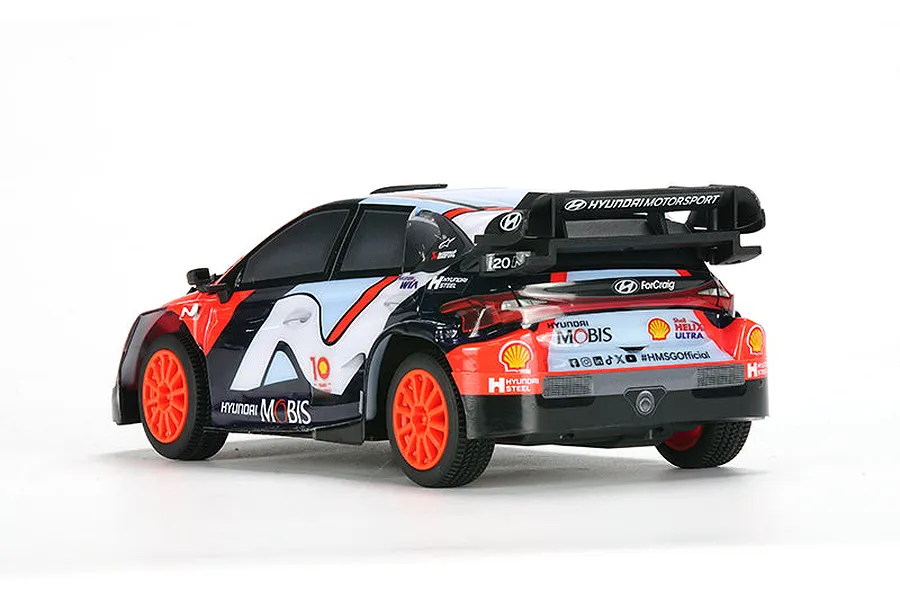 Rear three-quarter view of the Carisma Hyundai i20N Rally1 RC car in official Hyundai Motorsport livery with bright orange wheels.