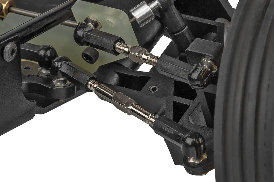 Close-up view of the front suspension and steering linkage assembly on a Team Associated RC10 buggy.