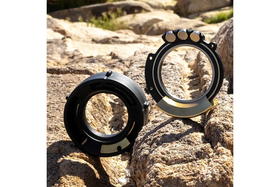 Two Pro-Line Rock-Tek tyre weight rings resting on a rocky outdoor surface.